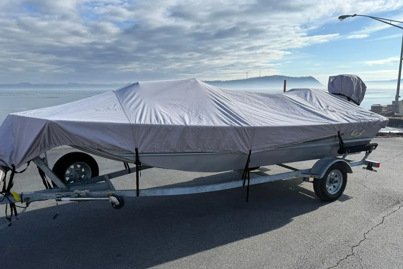 Slide: The Image of 2022 G3 Gator Tough 17 CCJ DLX boat covered on trailer by the waterfront. - 19