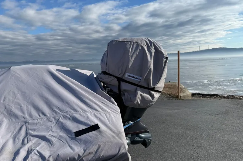 Slide: The Image of 2022 G3 Gator Tough 17 CCJ DLX boat covered near a serene lakeside. - 20