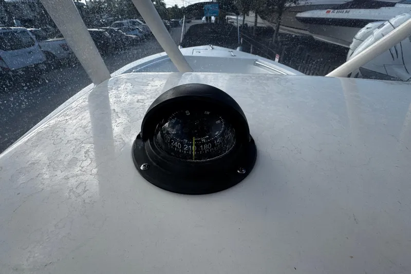 Slide: The Image of Compass on 2021 Cobia 220 Center Console boat dashboard, with marina background. - 10