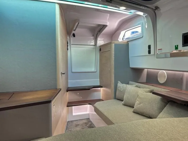 Slide: The Image of 2024 Axopar 45 XC Cross Cabin interior with modern seating and wooden accents. - 24