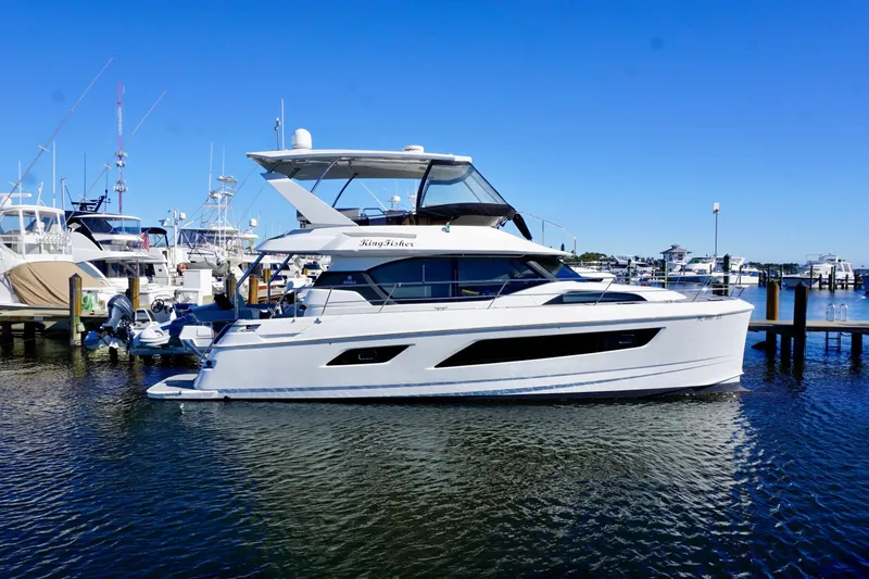 Slide: The Image of 2020 Aquila 44 Yacht docked in a marina under clear blue skies. - 3