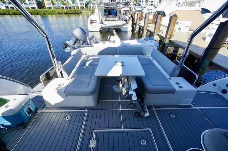 Slide: The Image of Aquila 44 Yacht 2020 with spacious deck seating and table, docked by the water. - 8