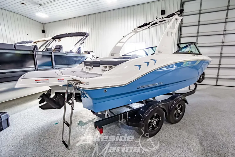 Slide: The Image of 2026 Chaparral 21 SSi boat in showroom, blue and white design on trailer. - 3