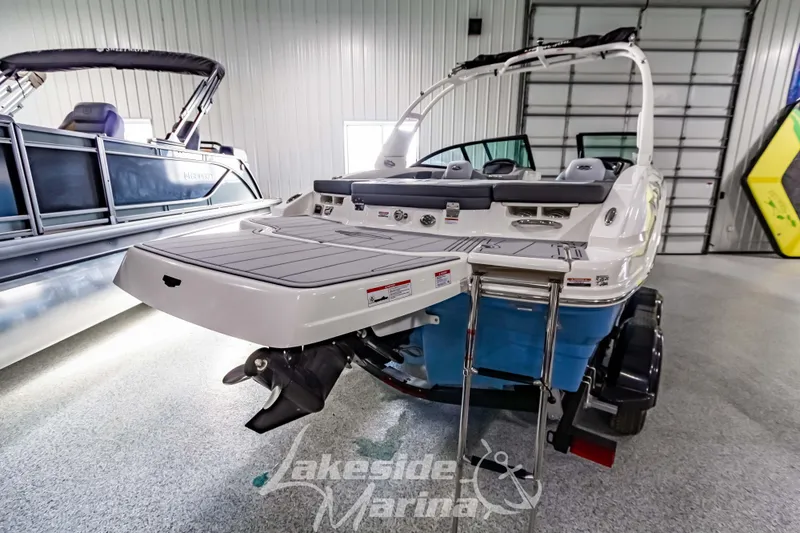 Slide: The Image of 2026 Chaparral 21 SSi boat in showroom, rear view with swim platform and ladder. - 4