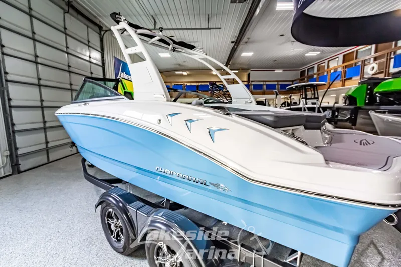 Slide: The Image of 2026 Chaparral 21 SSi boat in showroom, blue and white design, on trailer. - 7
