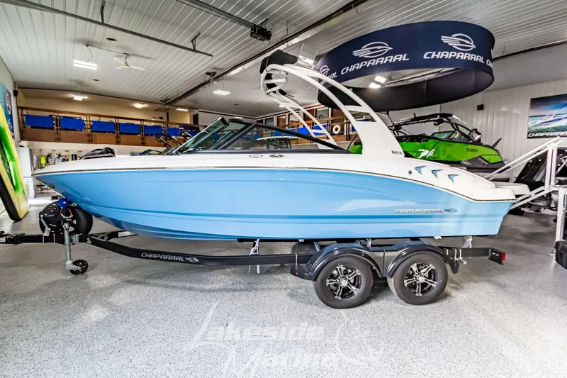 Slide: The Image of 2026 Chaparral 21 SSi boat in showroom, blue hull, on trailer. - 8