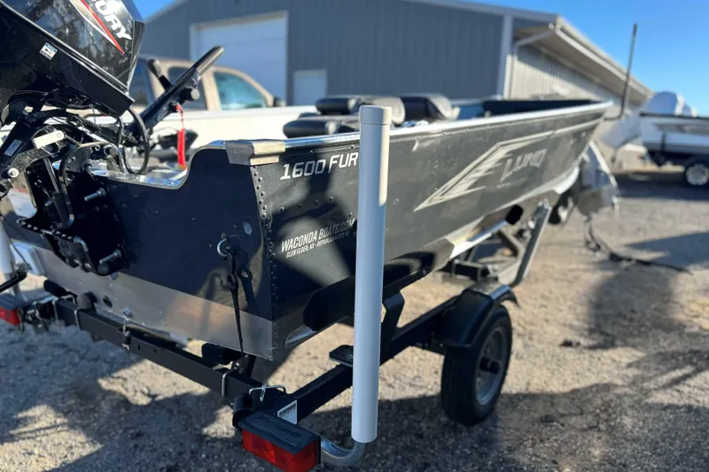 Slide: The Image of 2024 Lund 1600 Fury Tiller boat on trailer, outdoor setting. - 5