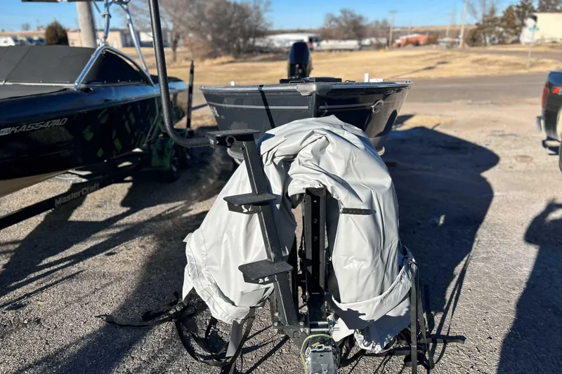 Slide: The Image of 2024 Lund 1600 Fury Tiller boat on trailer, covered, parked outdoors. - 6