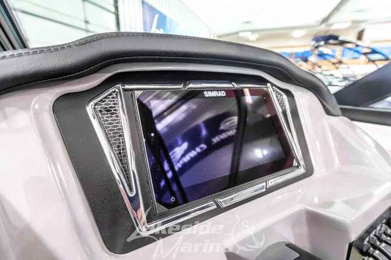 Slide: The Image of 2026 Chaparral 21 SSi boat dashboard featuring a Simrad display screen. - 22