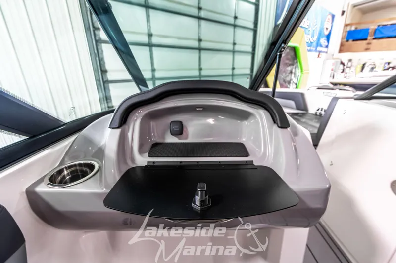 Slide: The Image of 2026 Chaparral 21 SSi boat dashboard with storage compartment and cup holder at Lakeside Marina. - 24