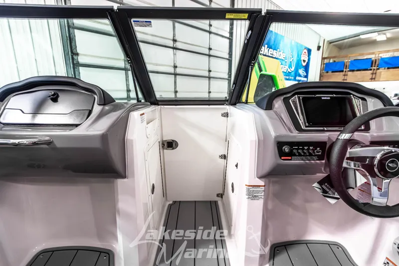 Slide: The Image of Interior view of 2026 Chaparral 21 SSi boat, featuring modern dashboard and steering wheel. - 25