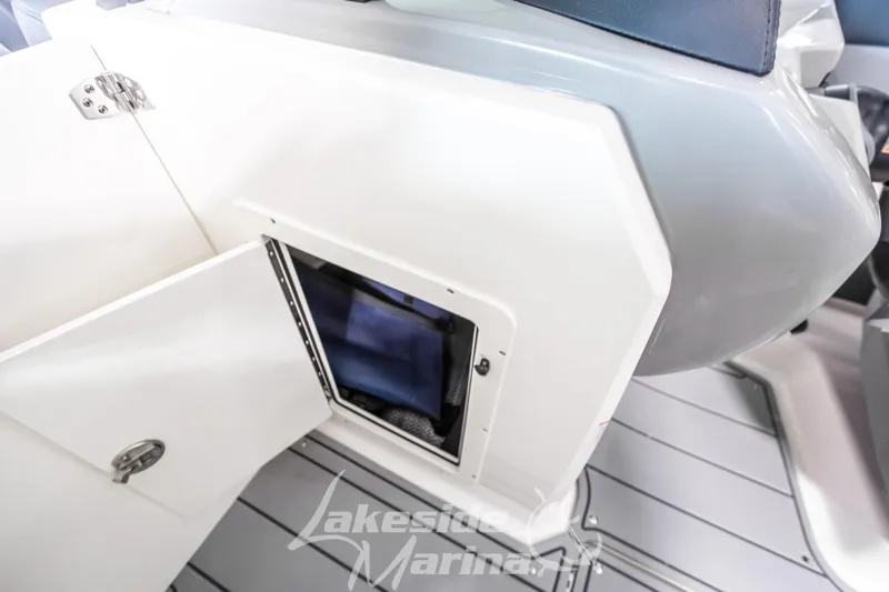 Slide: The Image of 2026 Chaparral 21 SSi boat storage compartment with open door, showcasing interior space. - 26