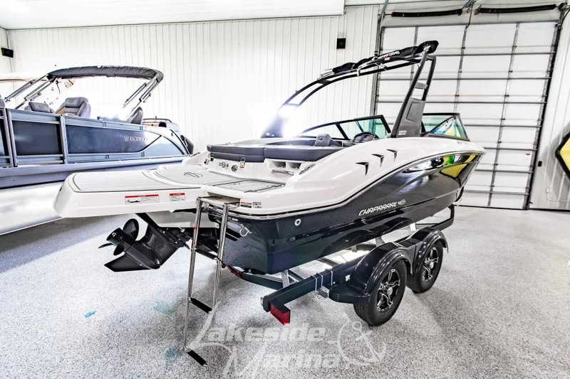 Slide: The Image of 2026 Chaparral 21 SSi boat in showroom, sleek design, dual-axle trailer. - 3