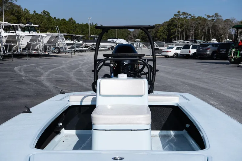 Slide: The Image of 2025 Chittum Skiffs 18 Islamorada boat in a marina with parked vehicles. - 15