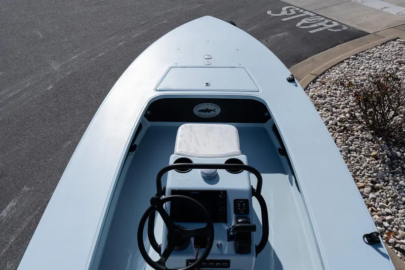 Slide: The Image of 2025 Chittum Skiffs 18 Islamorada boat, sleek design, parked on a paved surface. - 20
