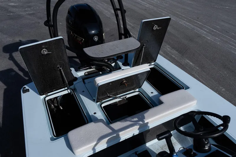 Slide: The Image of 2025 Chittum Skiffs 18 Islamorada boat interior with open storage compartments and steering wheel. - 23