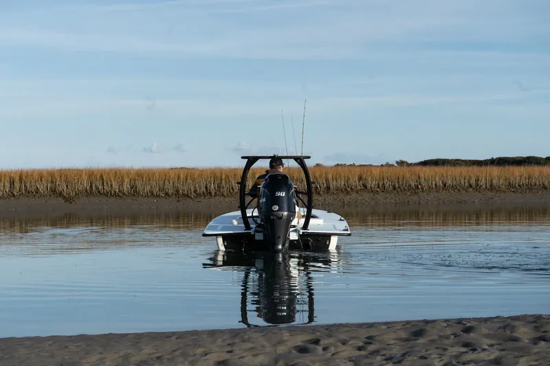 Slide: The Image of 2025 Chittum Skiffs 18 Islamorada boat on calm water near marshland. - 3