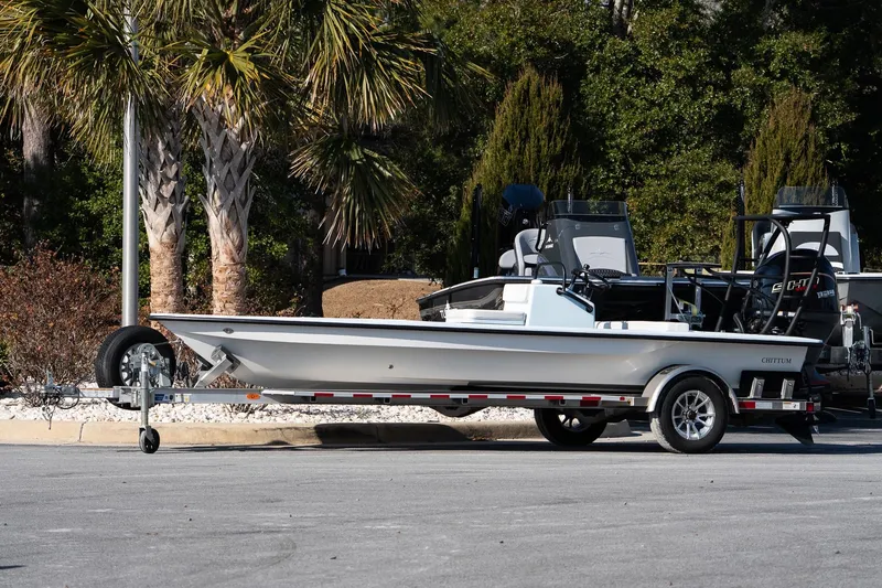 Slide: The Image of 2025 Chittum Skiffs 18 Islamorada boat on trailer, parked near palm trees. - 8