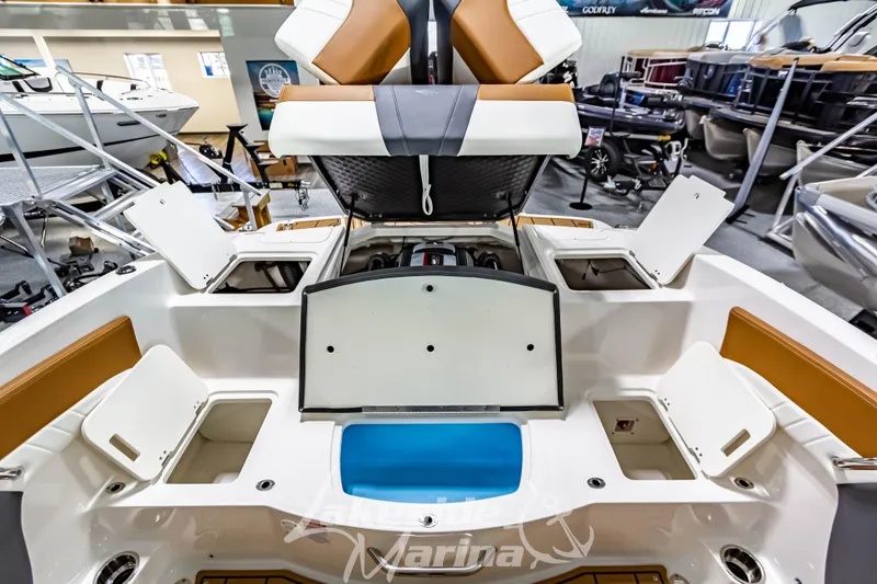 Slide: The Image of 2026 Chaparral 21 SSi boat interior with modern seating and dashboard in showroom. - 13