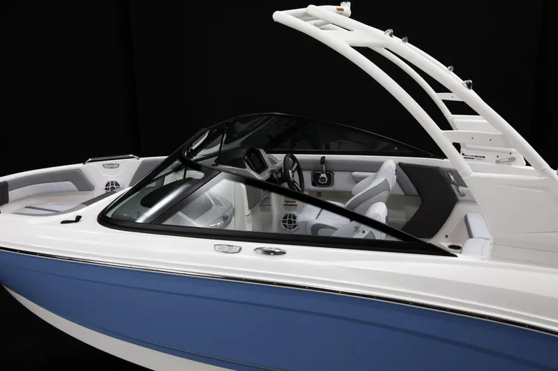 Slide: The Image of 2026 Chaparral 21 SSi boat in showroom, rear view with trailer and outboard motor. - 5