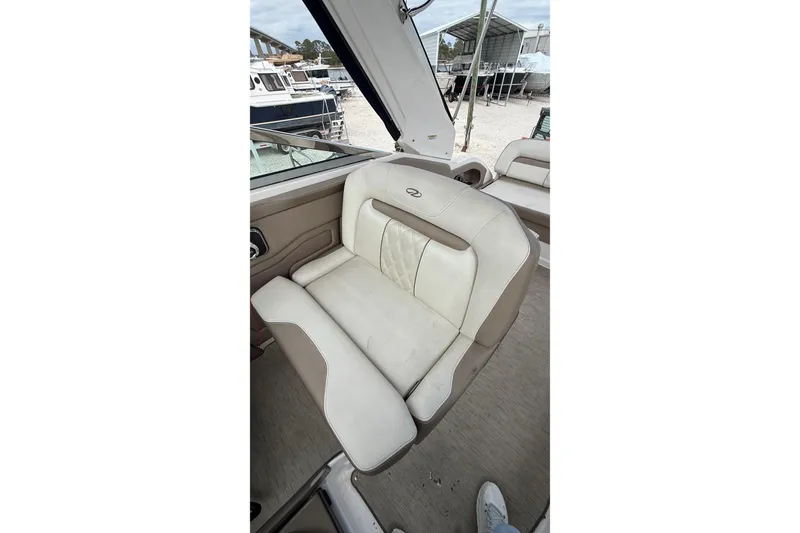 Slide: The Image of 2018 Regal 28 Express boat interior with beige seating and cup holders. - 13