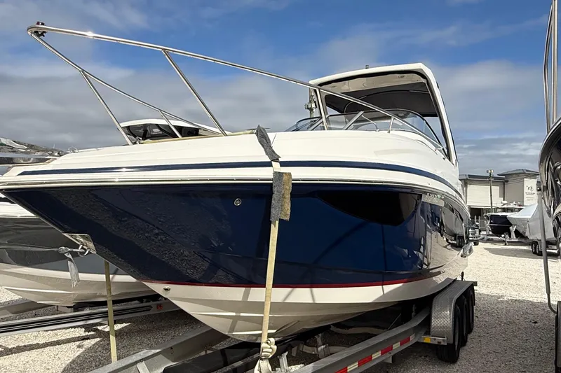 Slide: The Image of 2018 Regal 28 Express boat on trailer, blue and white hull with red stripe. - 4