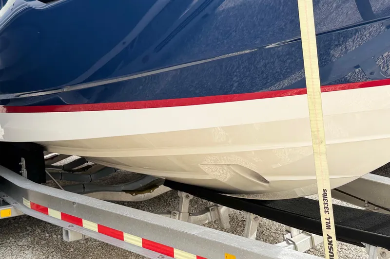 Slide: The Image of 2018 Regal 28 Express boat with sleek blue hull, parked outdoors. - 5