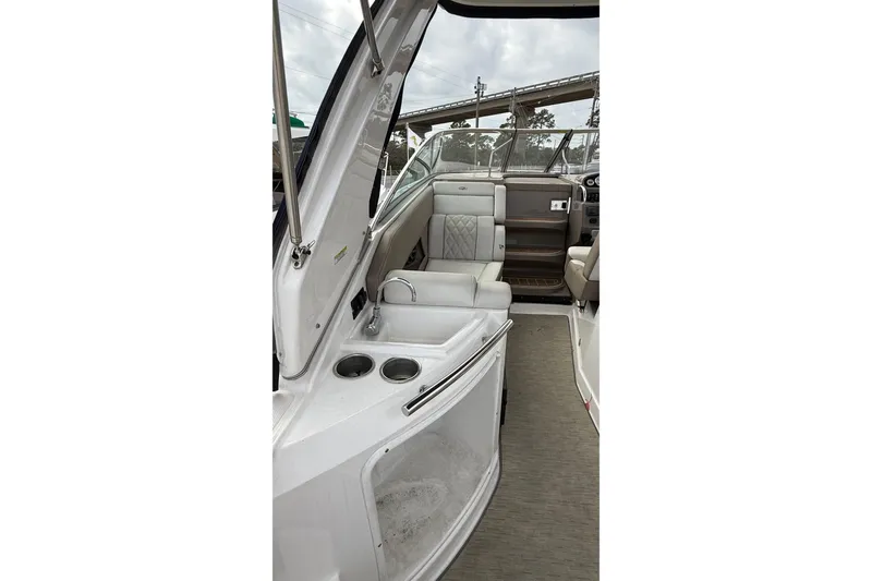 Slide: The Image of 2018 Regal 28 Express boat interior with beige seating and steering console. - 9