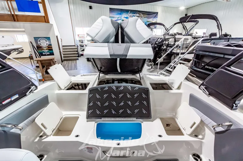 Slide: The Image of 2026 Chaparral 21 SSi boat interior with open storage compartments in a showroom. - 13