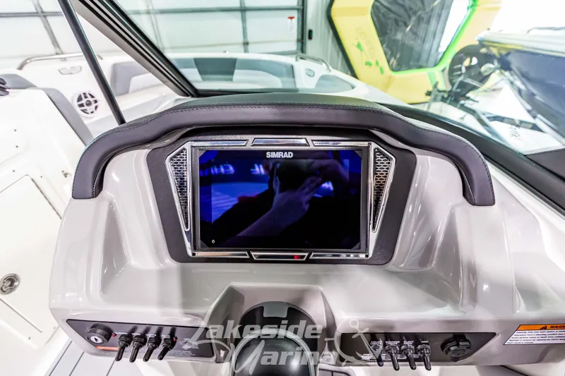 Slide: The Image of 2026 Chaparral 21 SSi boat dashboard with Simrad display and control panel. - 19