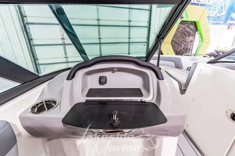 Slide: The Image of 2026 Chaparral 21 SSi boat interior with dashboard and cup holder in marina setting. - 21