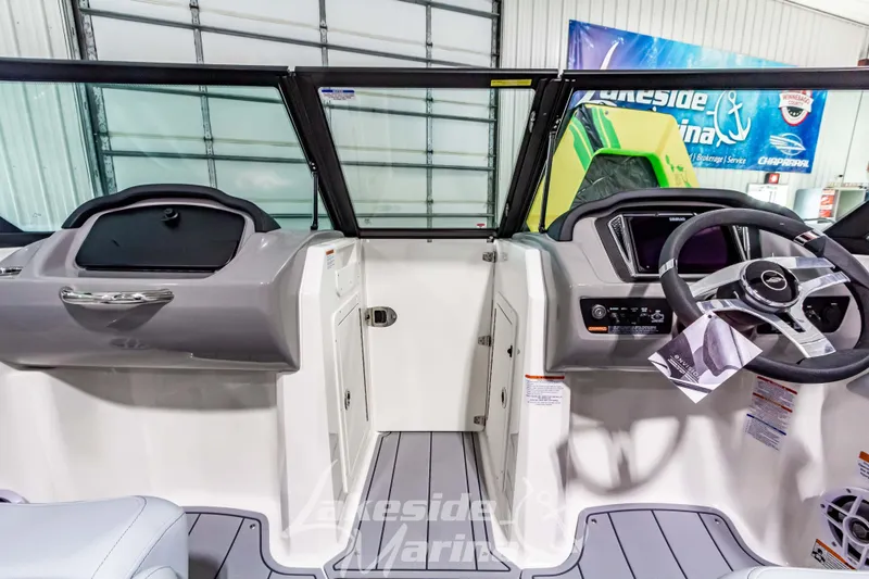 Slide: The Image of 2026 Chaparral 21 SSi boat interior with steering wheel and dashboard in showroom. - 22