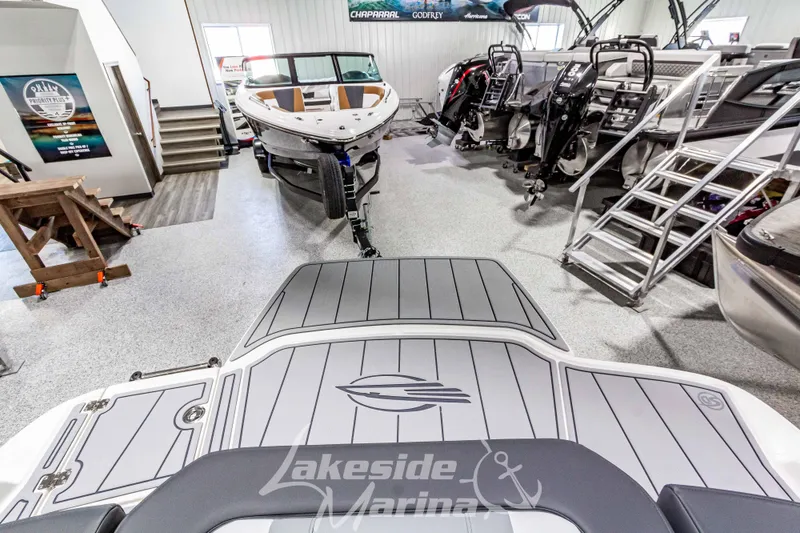 Slide: The Image of 2026 Chaparral 21 SSi boat displayed in a marina showroom with other boats. - 8