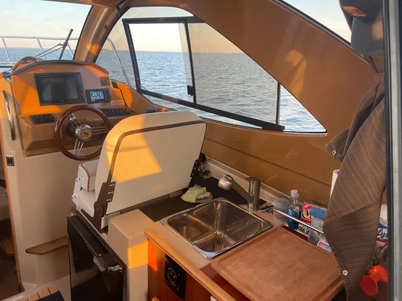 Slide: The Image of Interior of a 2017 Cutwater C-24 boat with helm and kitchenette. - 6