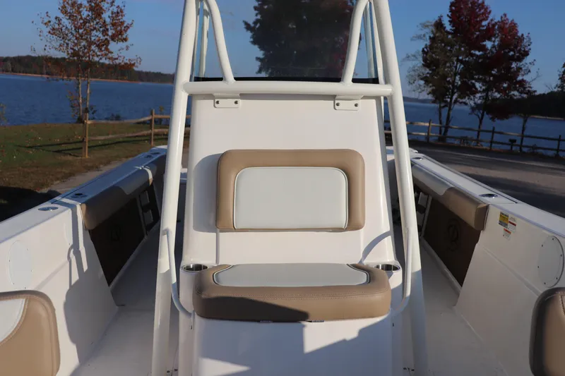 Slide: The Image of 2024 Sea Born LX24 Center Console boat interior with seating, near a scenic lake. - 4