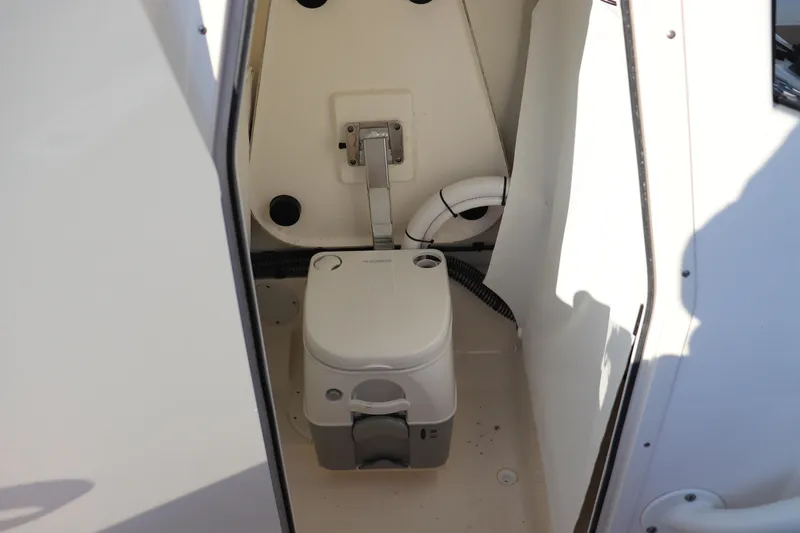 Slide: The Image of 2024 Sea Born LX24 Center Console boat interior with compact marine toilet. - 6