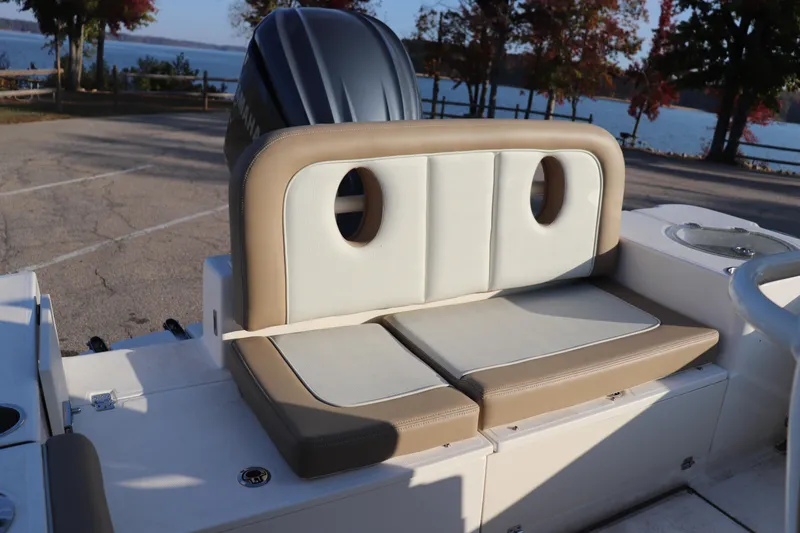 Slide: The Image of 2024 Sea Born LX24 Center Console boat with cushioned seating, parked near a scenic lake. - 9