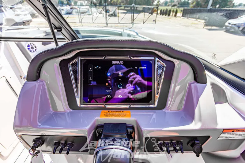 Slide: The Image of 2026 Chaparral 21 SSi OB boat dashboard with Simrad display and control panel. - 24