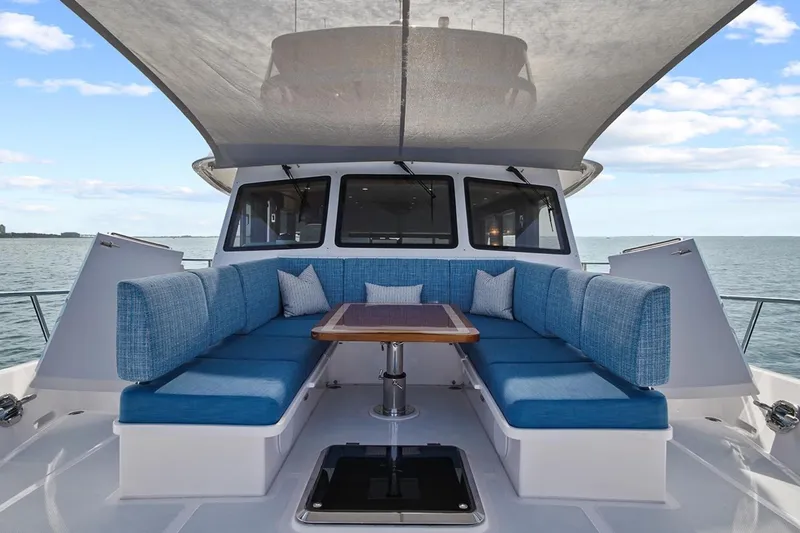 Slide: The Image of Luxurious 2023 Outer Reef Yachts 670 Azure cockpit with blue seating and ocean view. - 6