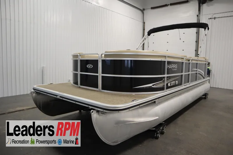 Slide: The Image of 2013 Harris Cruiser 220 pontoon boat in indoor storage, Leaders RPM logo visible. - 1