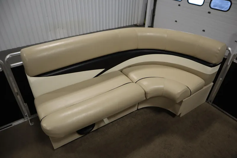 Slide: The Image of 2013 Harris Cruiser 220 boat seating, beige and black curved design, indoor setting. - 12