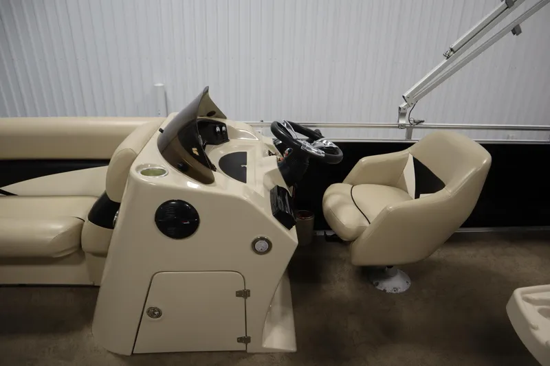 Slide: The Image of 2013 Harris Cruiser 220 boat interior with steering console and beige seating. - 17