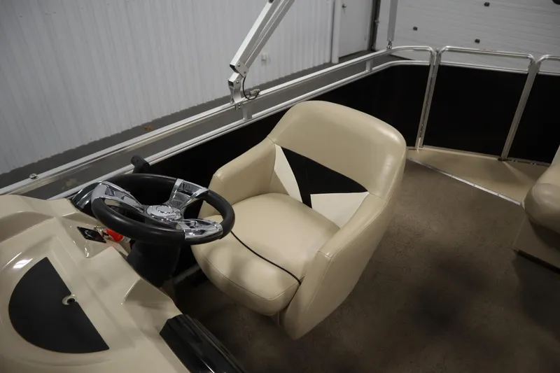 Slide: The Image of 2013 Harris Cruiser 220 boat interior with steering wheel and beige seating. - 27