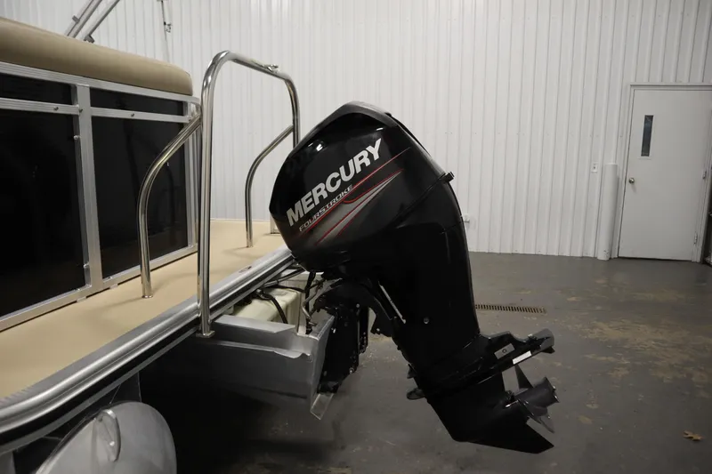 Slide: The Image of 2013 Harris Cruiser 220 with Mercury FourStroke outboard motor in a garage setting. - 36
