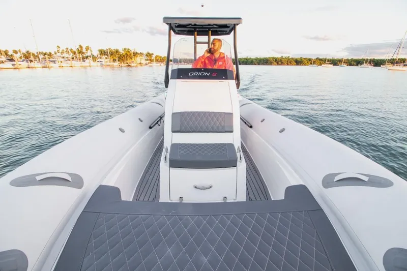 Slide: The Image of 2024 Northstar Orion 8 boat on calm water with a person at the helm. - 7