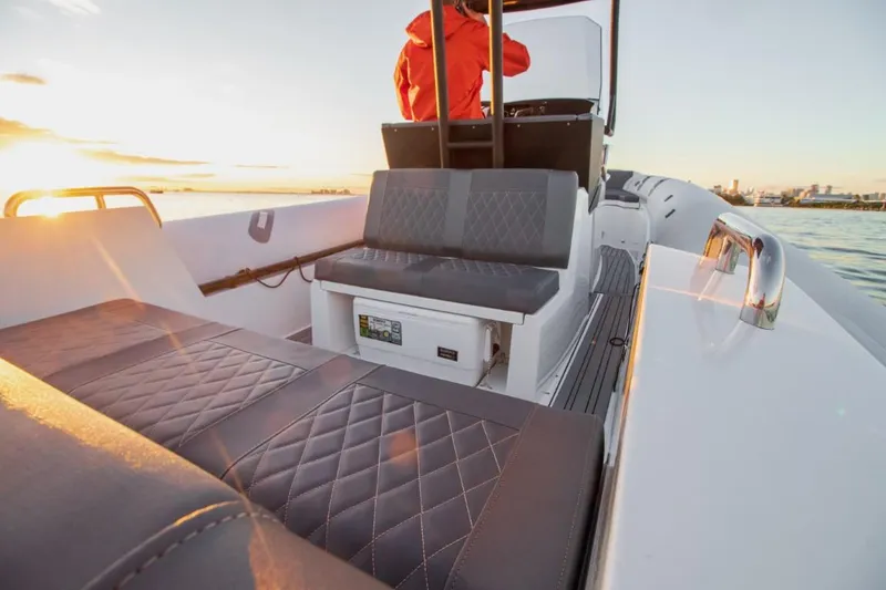 Slide: The Image of 2024 Northstar Orion 8 boat interior with cushioned seating at sunset. - 14