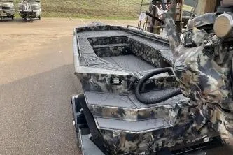 Slide: The Image of 2026 Excel 1751 Viper F4 boat with camouflage design, parked on a trailer. - 15