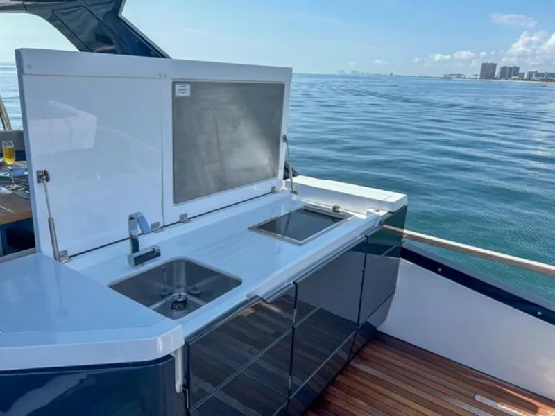Slide: The Image of 2024 Fairline Squadron 68 yacht with outdoor kitchen, featuring dual sinks and ocean view. - 46