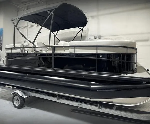The Image of 2024 Vision Marine Technologies WX Tritoon boat on trailer in indoor setting. - 0