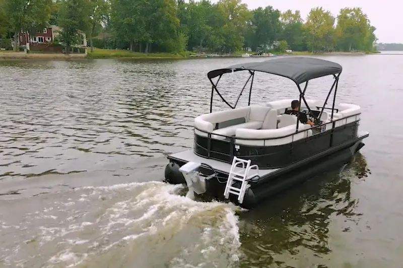 Slide: The Image of 2024 Vision Marine Technologies WX Tritoon cruising on a lake with lush green surroundings. - 5